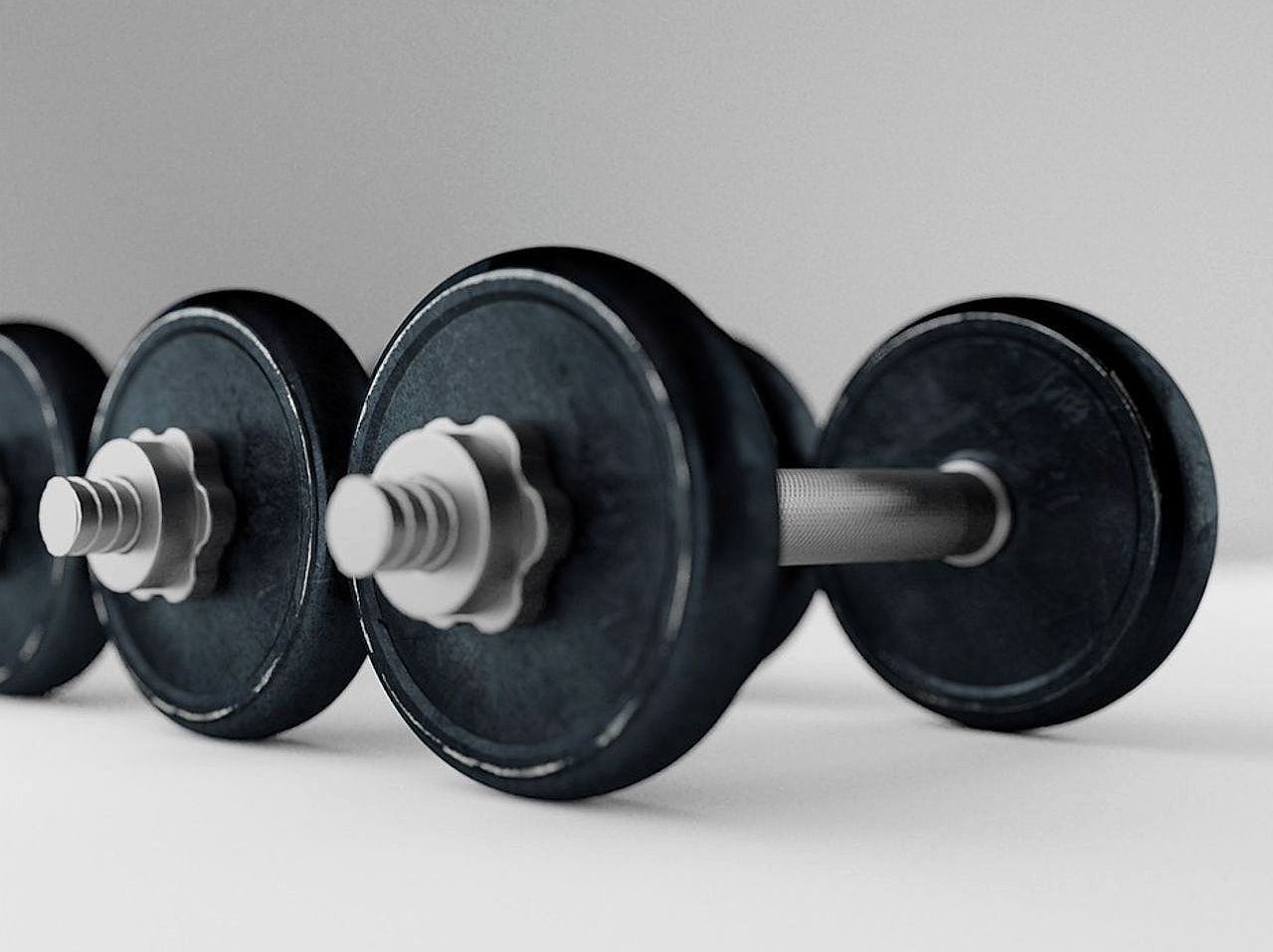Dumbbell ağırlıklarının düzenli şekilde yerleştirildiği ahşap sehpa